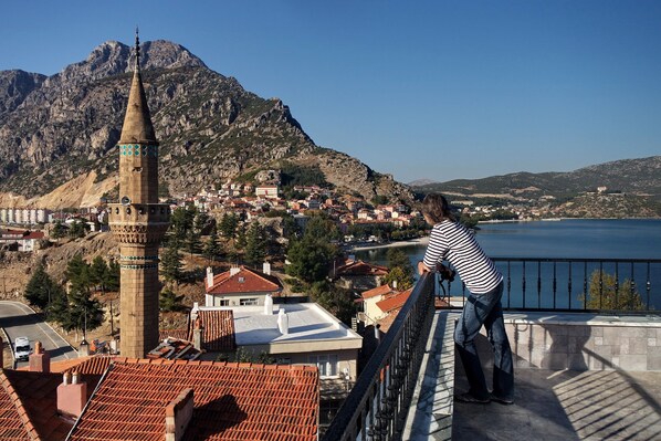 A view of a town with a prominent tower and a body of water in the background. - Lale Pansiyon (Egirdir)