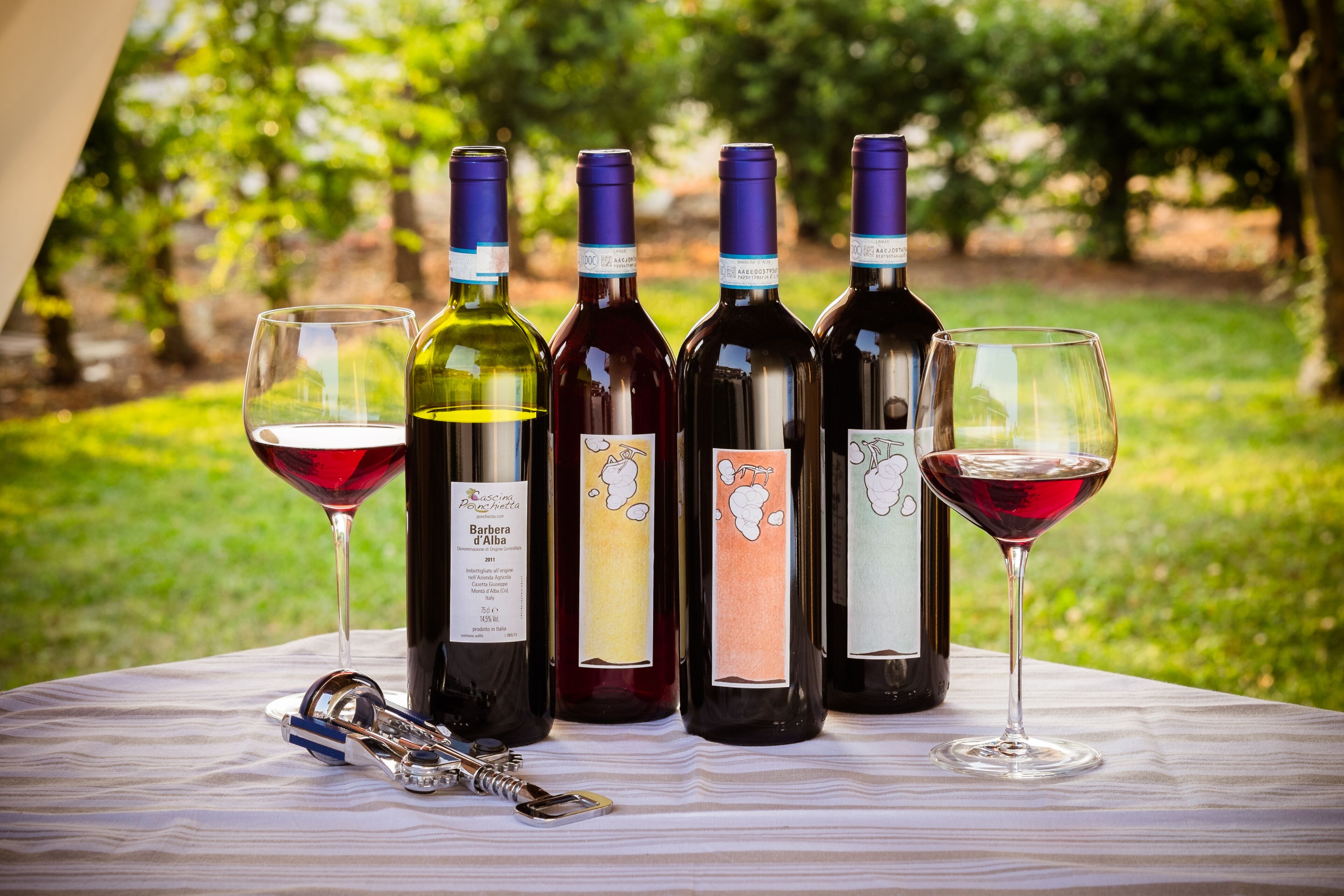 Une table avec des bouteilles et des verres à vin, des clés et un tire-bouchon.