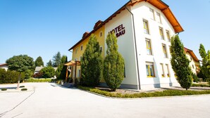 A hotel building with a yellow facade and a sign that reads "HOTEL BAU". - Hotel Bau (Maribor)