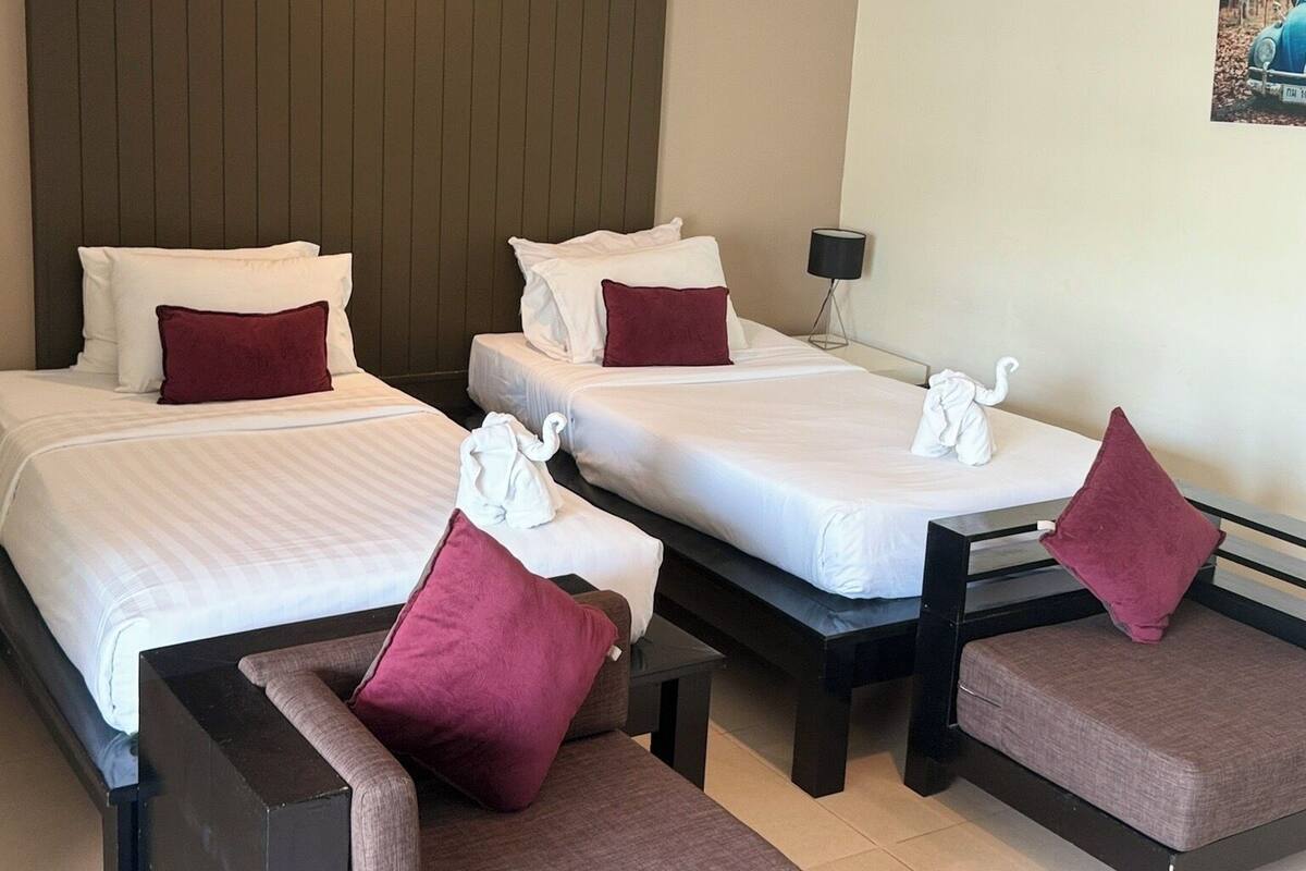Une chambre d’hôtel avec deux lits, un canapé et une petite table.