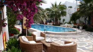 A poolside area with wicker furniture and a pool. - Su Hotel (Bodrum)