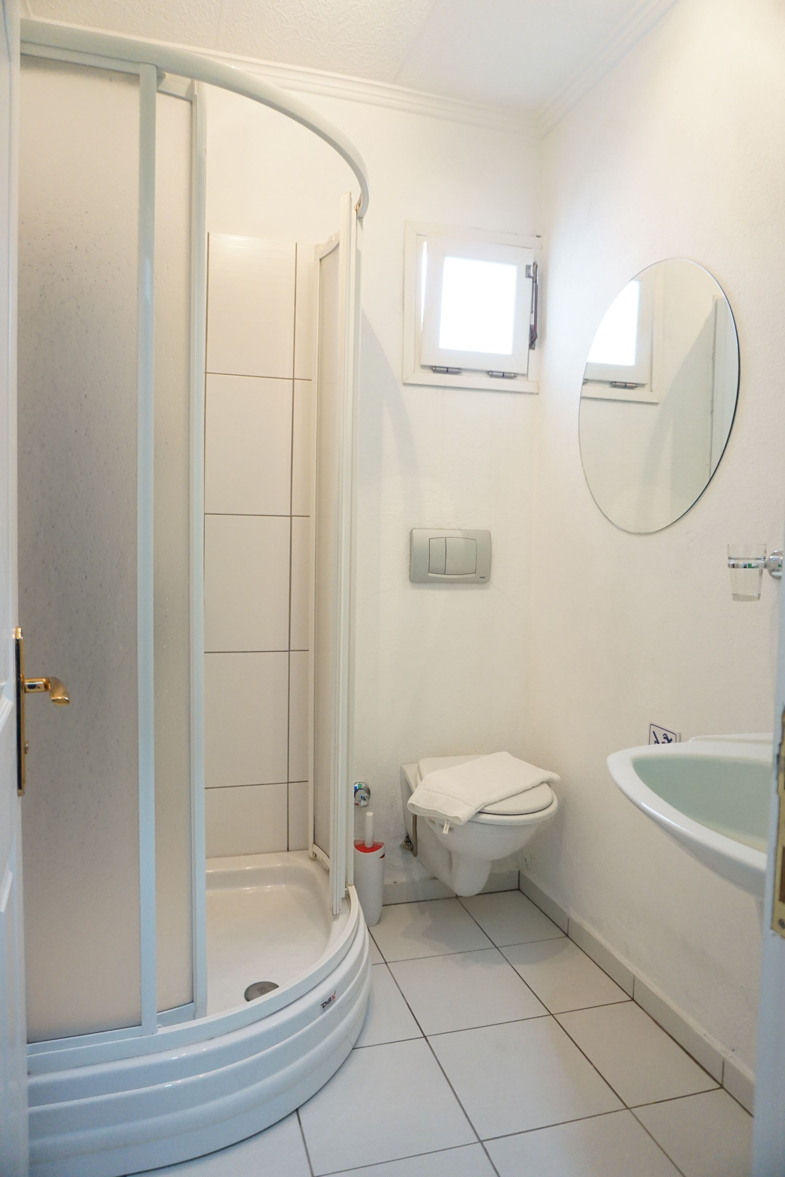 Een badkamer met douche, toilet en bad.