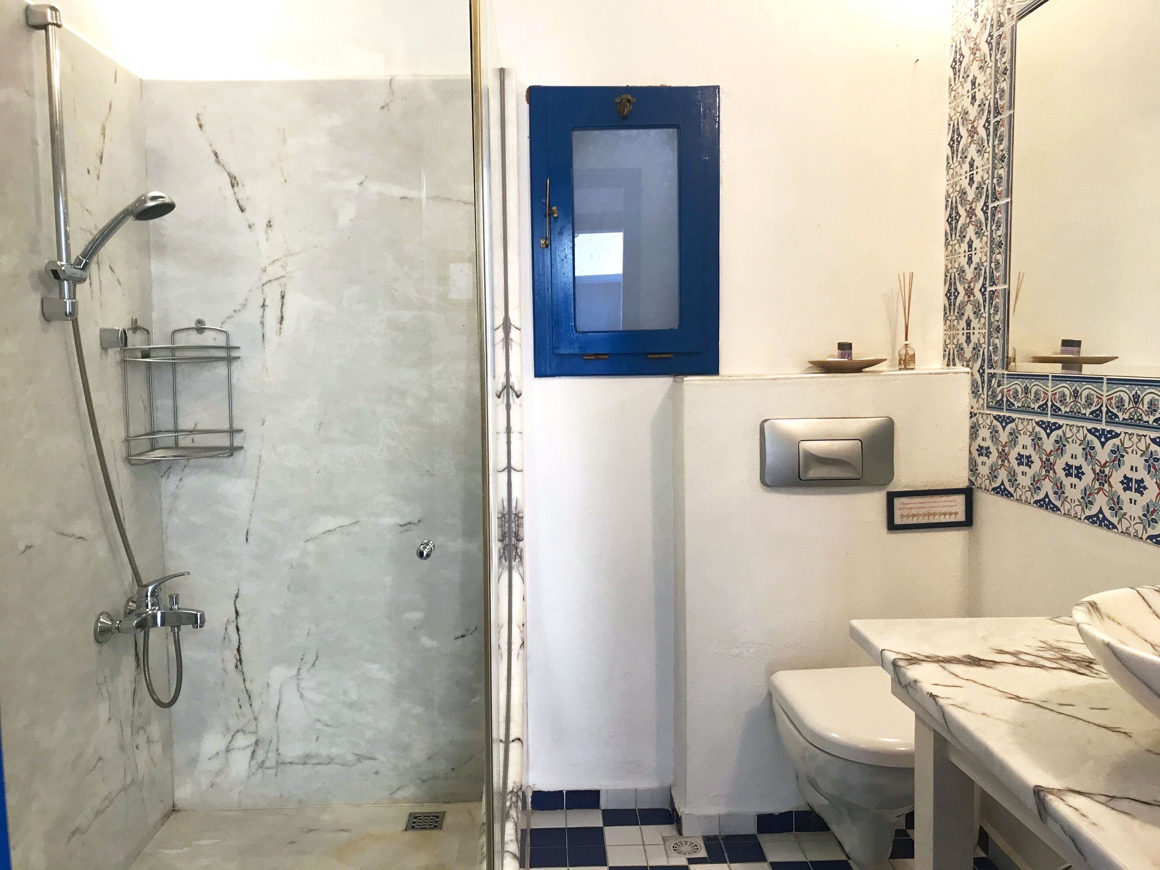 A bathroom with a shower, toilet, and sink.