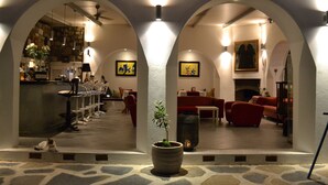 A hotel lobby with a stone floor, a reception area, seating, and a fireplace. - Su Hotel (Bodrum)