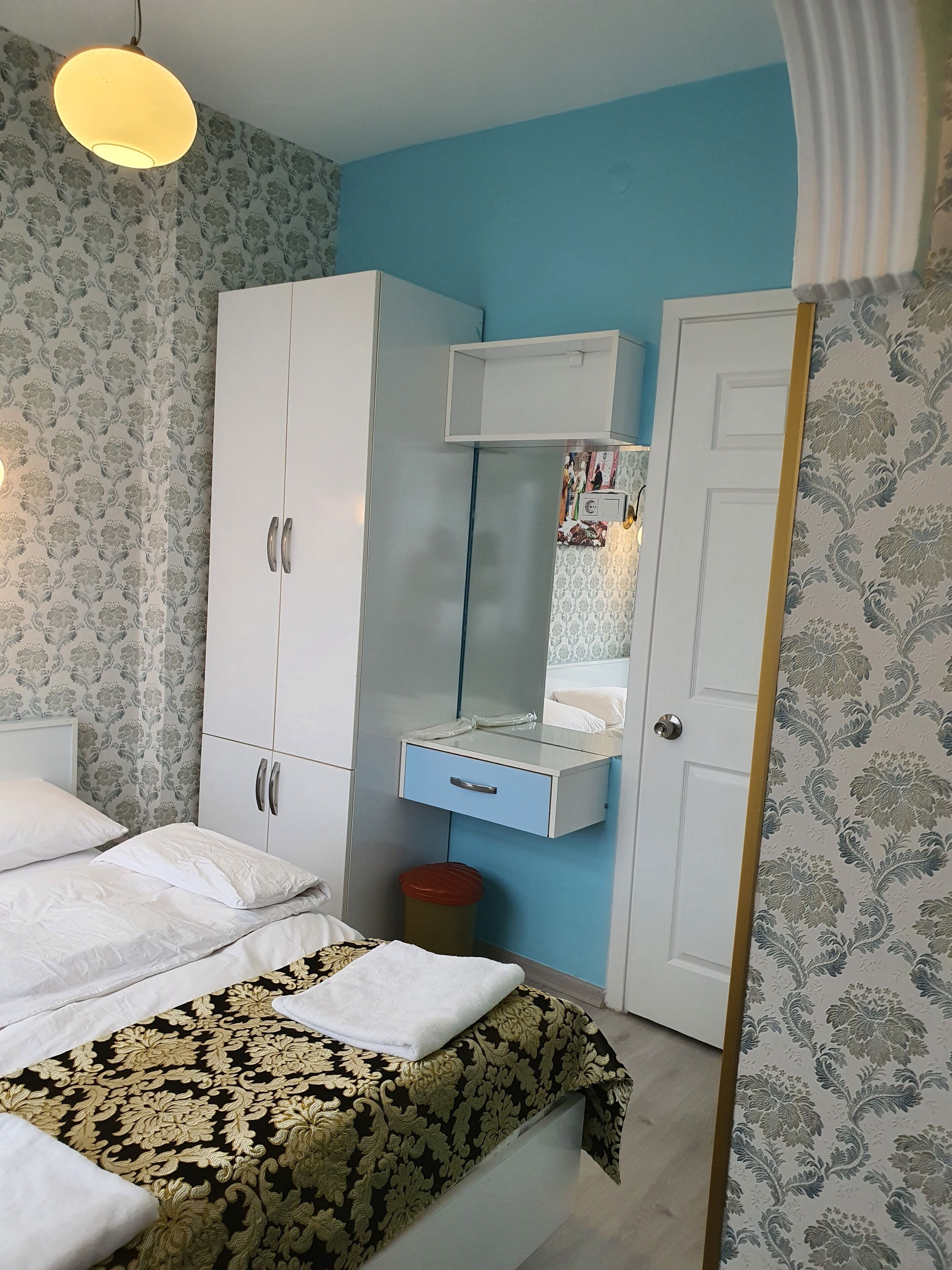 A bedroom with a bed, wardrobe, and a mirror cabinet.