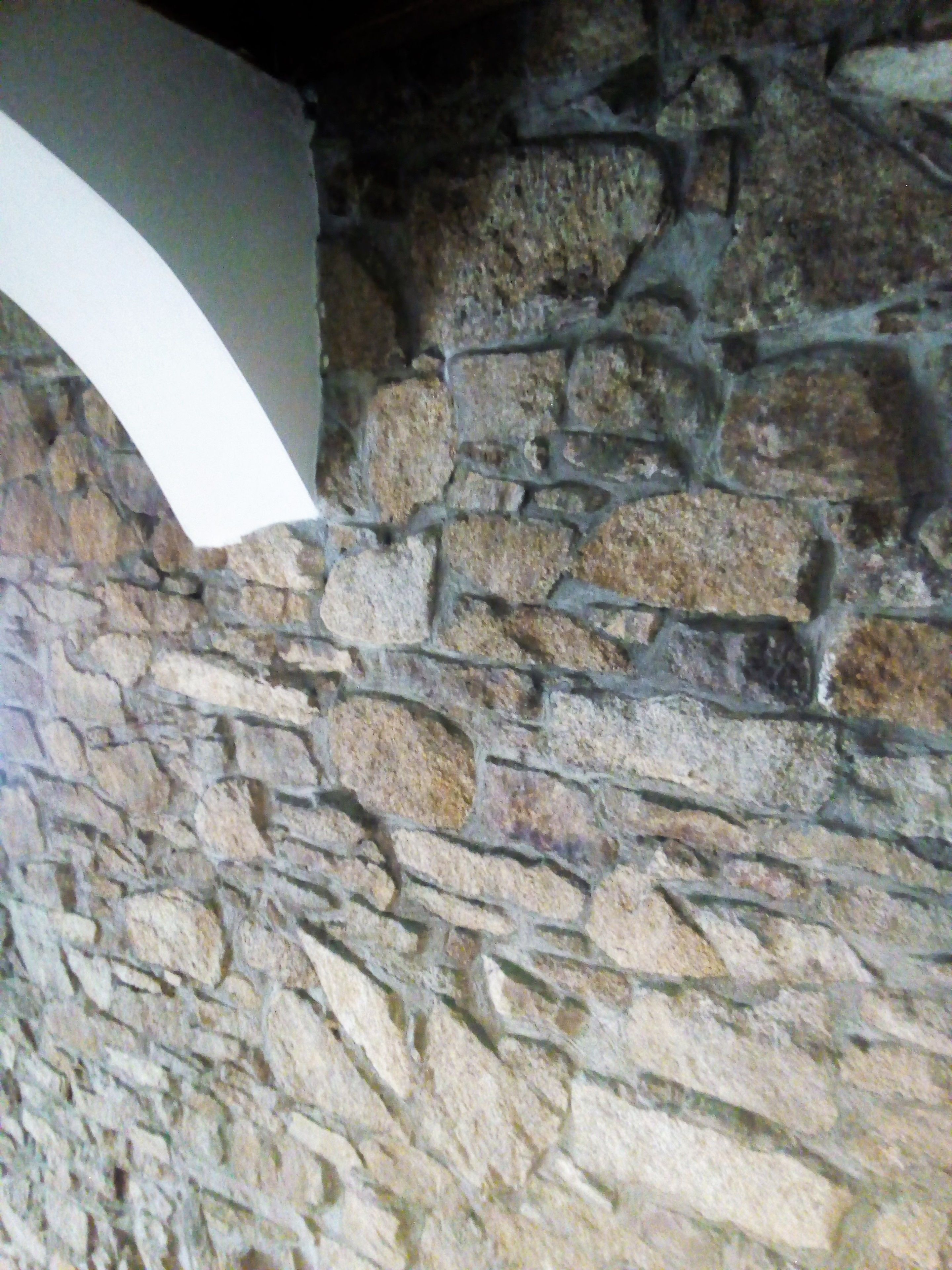 A stone wall with a white arch.