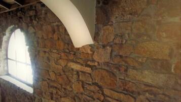 A stone wall with a large arched window.