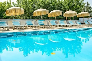 Een seizoensgebonden buitenzwembad en parasols bij het zwembad