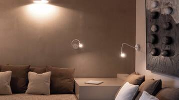 Una sala de estar moderna con un sofá seccional, una mesita auxiliar y un aplique de pared.