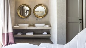 Un baño moderno con dos lavamanos, un espejo grande y una puerta.