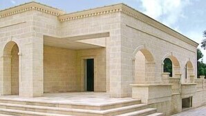 A building with a symmetrical facade, featuring a central entrance with a door and two side entrances with arches. There are steps leading up to the entrance. - La Vigna Vecchia (Fasano)