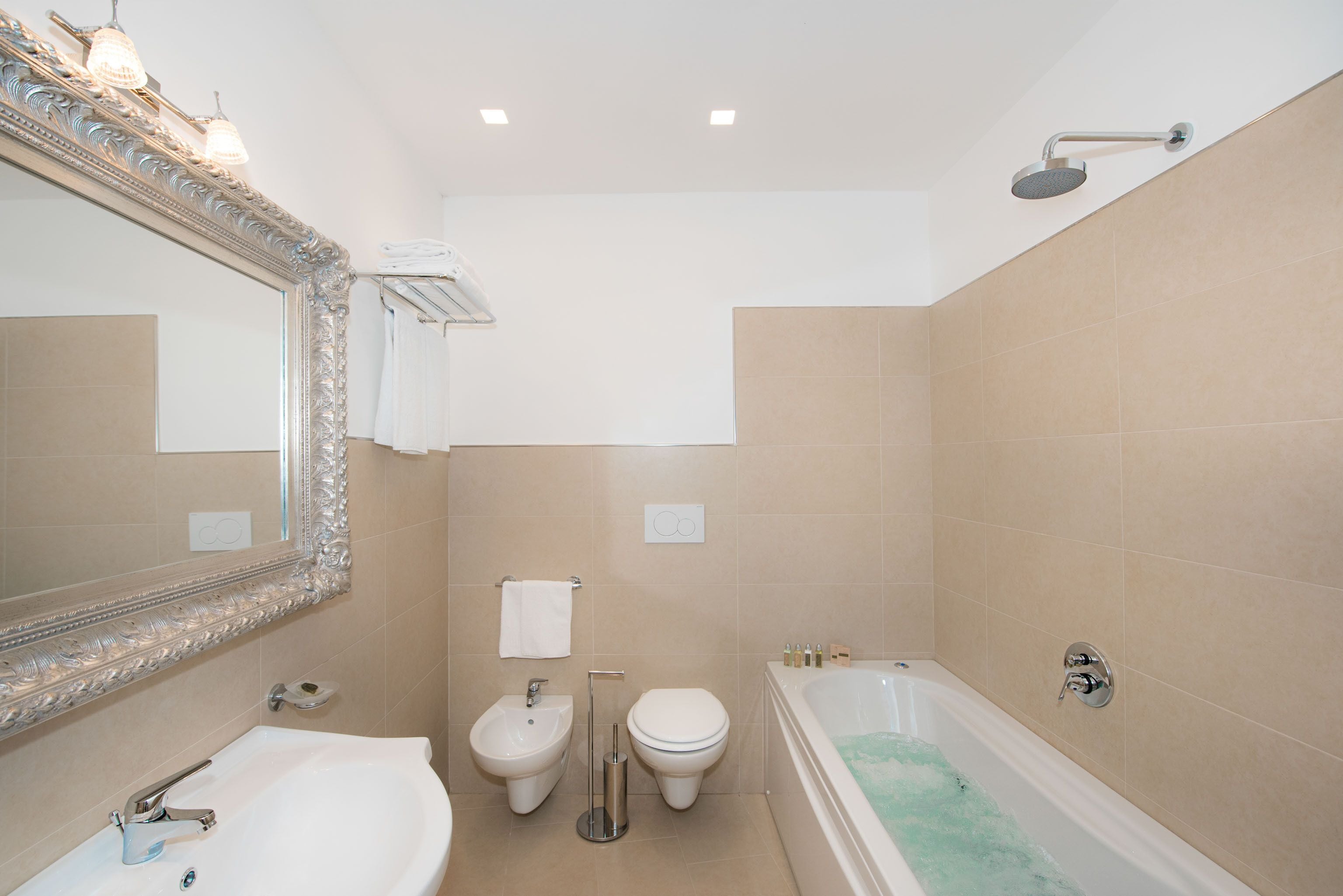 A bathroom with a sink, bidet, toilet, and bathtub.