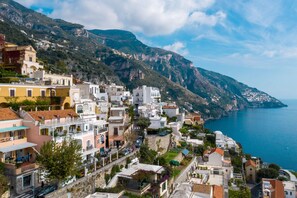 A coastal town with buildings along a hillside overlooking the sea.