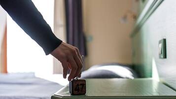 A hand placing a wooden block with the number 47 on a wooden surface, likely a hotel room.