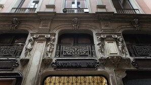 A building facade with ornate architectural details, including statues and a balcony with wrought iron railings. - Las Ramblas Pasaje Bacardi Apartments (Barcelona)