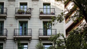 A multi-story building with balconies, green shutters, and decorative iron railings. - Las Ramblas Pasaje Bacardi Apartments (Barcelona)
