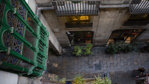 A multi-story building with balconies, green shutters, and potted plants. - Las Ramblas Pasaje Bacardi Apartments (Barcelona)