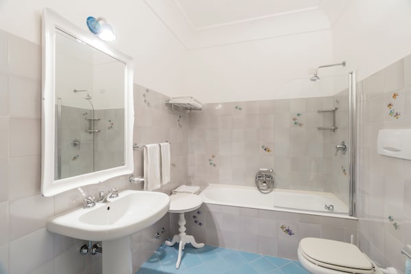 A bathroom with a sink, toilet, and bathtub. - Villa La Tartana (Positano)