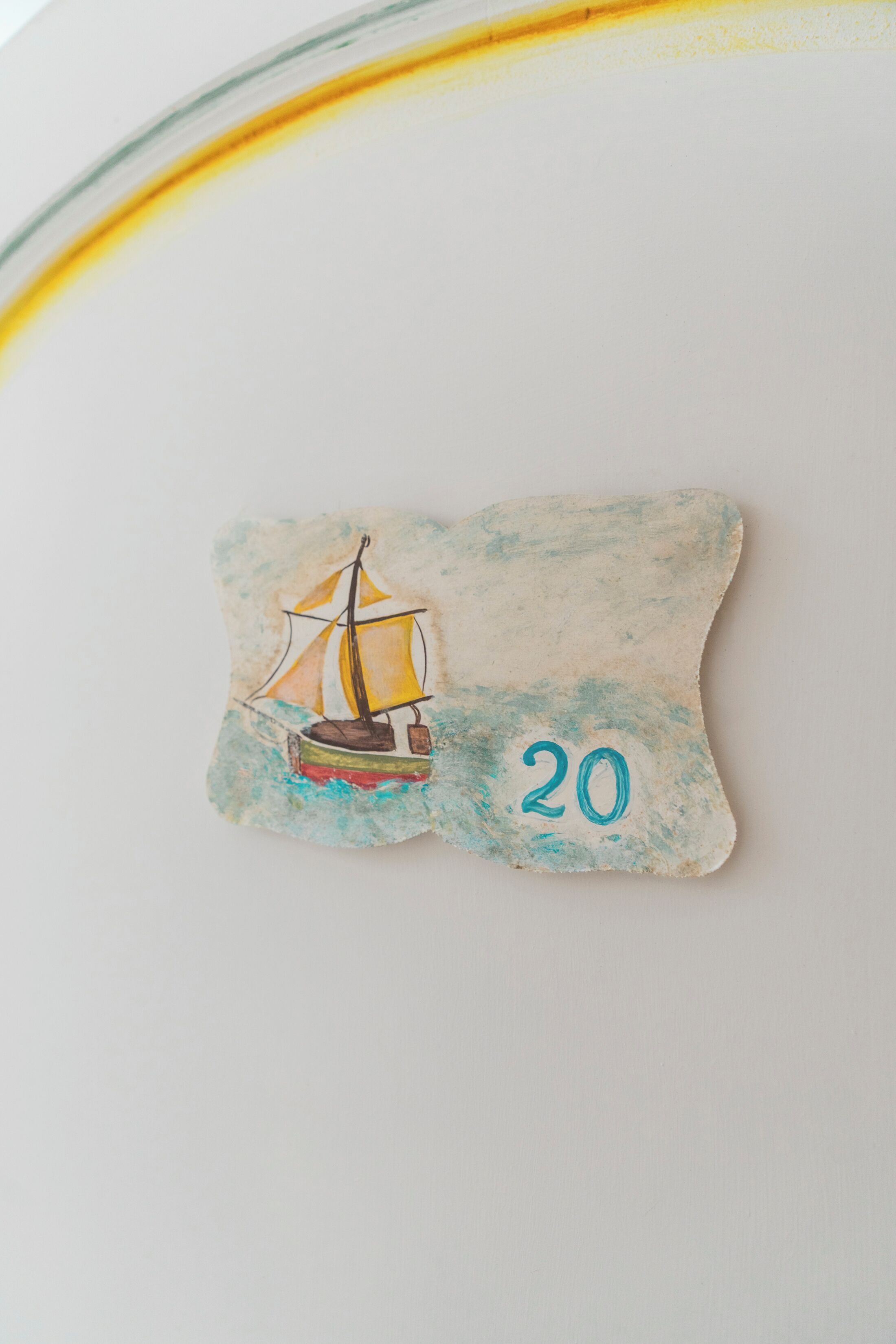 Un objet décoratif représentant un voilier et le chiffre 20.