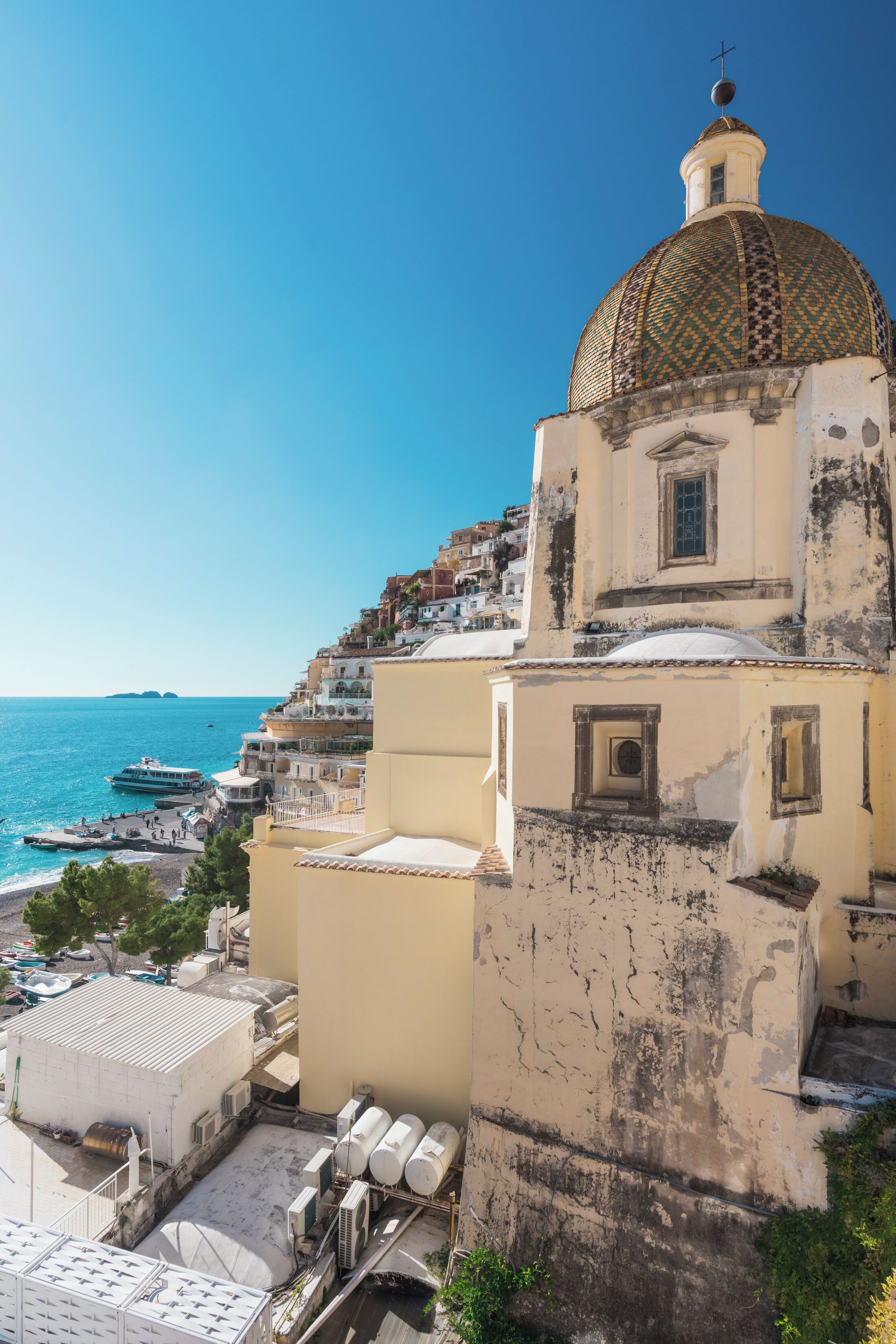 A coastal building with a dome, a staircase, and a view of the sea.