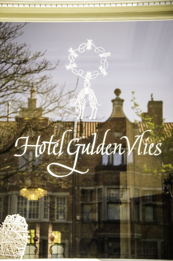 A window with the text "Hotel Gulden Vlies" and a decorative emblem. - Hotel Gulden Vlies (Bruges)