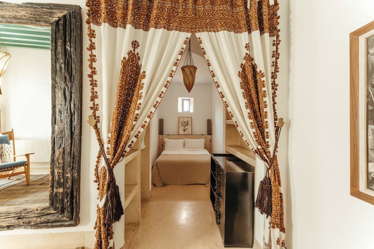 A bedroom with a bed, a bedside table, and a wardrobe.