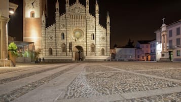 A historic cathedral with a large central rose window and multiple spires, surrounded by cobblestone streets and traditional buildings.