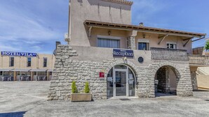 Un hotel con recepción, fachada de piedra y un cartel con el nombre 'VILA'.