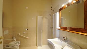 Een badkamer met toilet, wastafel, douche en spiegel.
