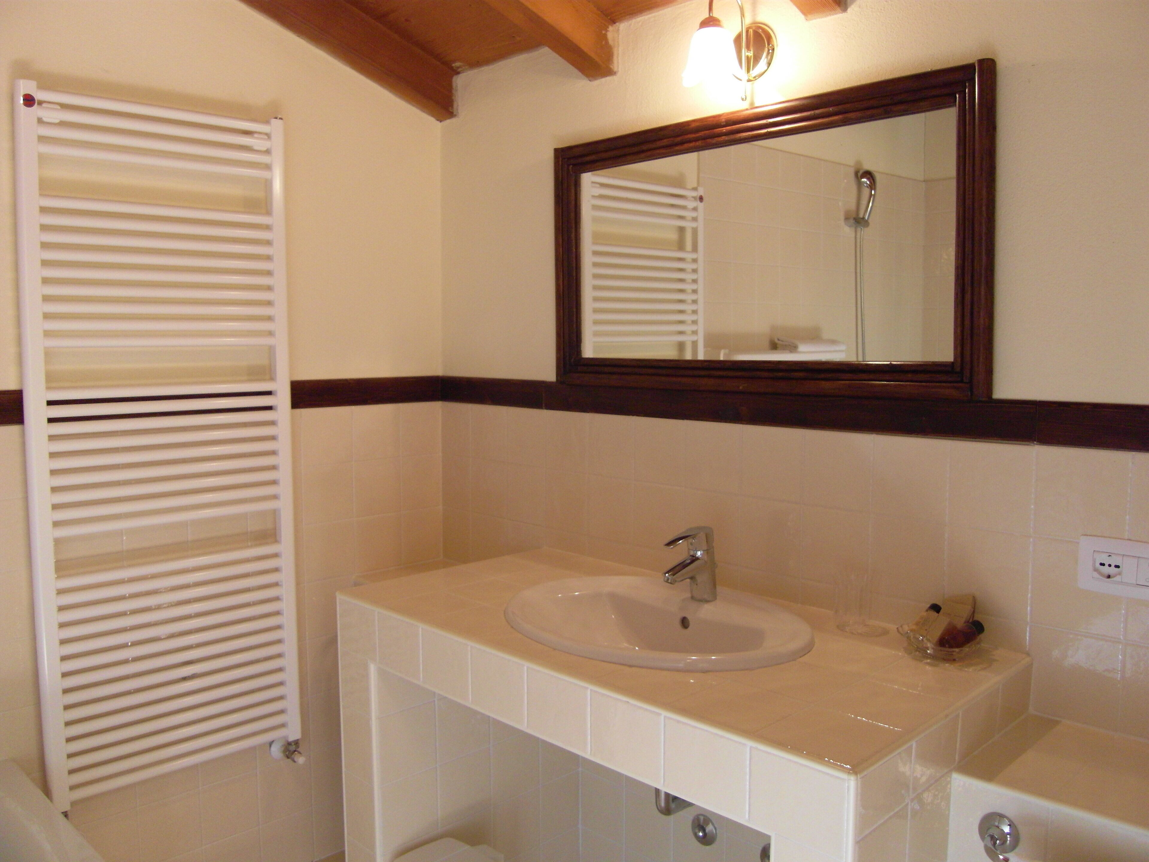 A bathroom with a white sink, a mirror, and a towel rack.