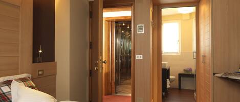 Ein Hotelzimmer mit Bett, Holzschrank, Badezimmer mit Toilette und Duschbereich.
