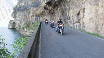 Une route étroite, bordée d’une barrière en béton d’un côté et d’une falaise abrupte de l’autre.