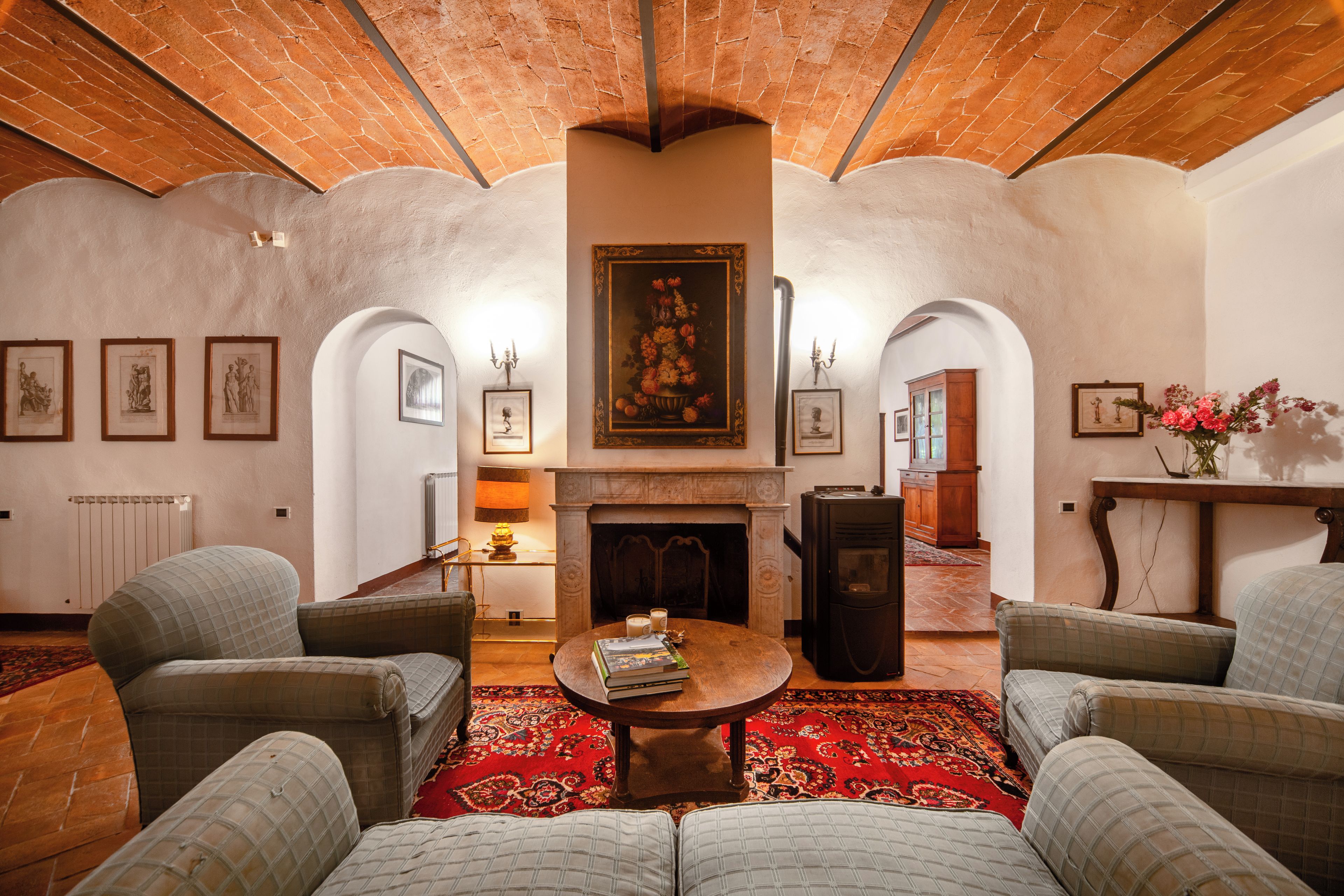 Una habitación con chimenea, zona de estar y obras de arte en las paredes.