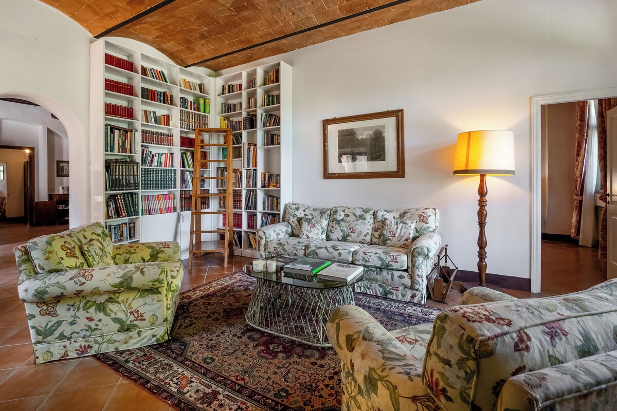 A living room with a sofa set, a coffee table, a bookshelf, and a lamp.