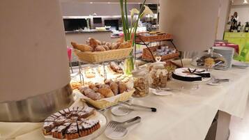 Ein reichhaltiges Buffet mit verschiedenen Gebäcken, einer Torte und Geschirr.