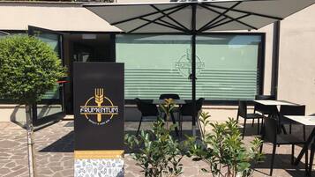 Un área de estar al aire libre con el logotipo de 'FRUMENTUM' y un cartel.