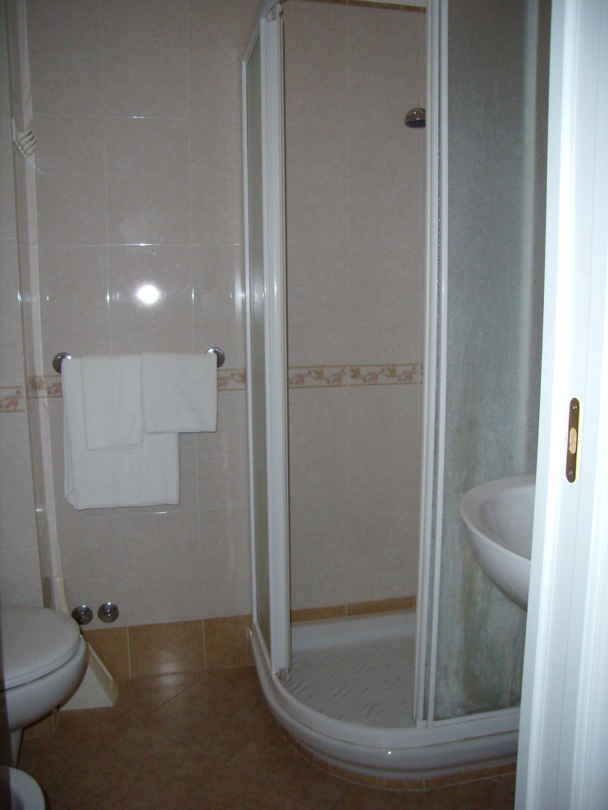 Une salle de bain avec une douche, des toilettes et un lavabo.