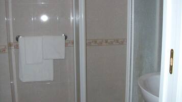Une salle de bain avec une douche, des toilettes et un lavabo.