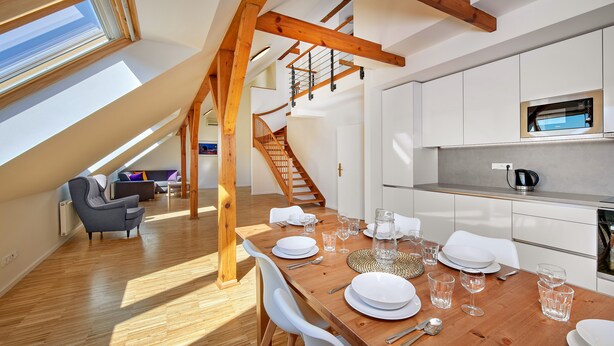 A modern kitchen with white cabinets, a stainless steel countertop, and a built-in microwave. - DownTown Suites Kodanská (Prague)