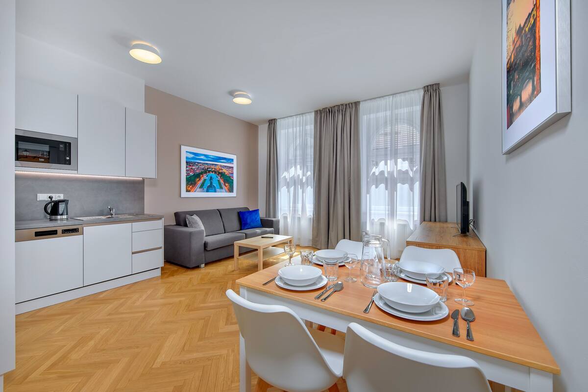 Uma sala moderna com área de jantar, cozinha e uma grande janela com cortinas.