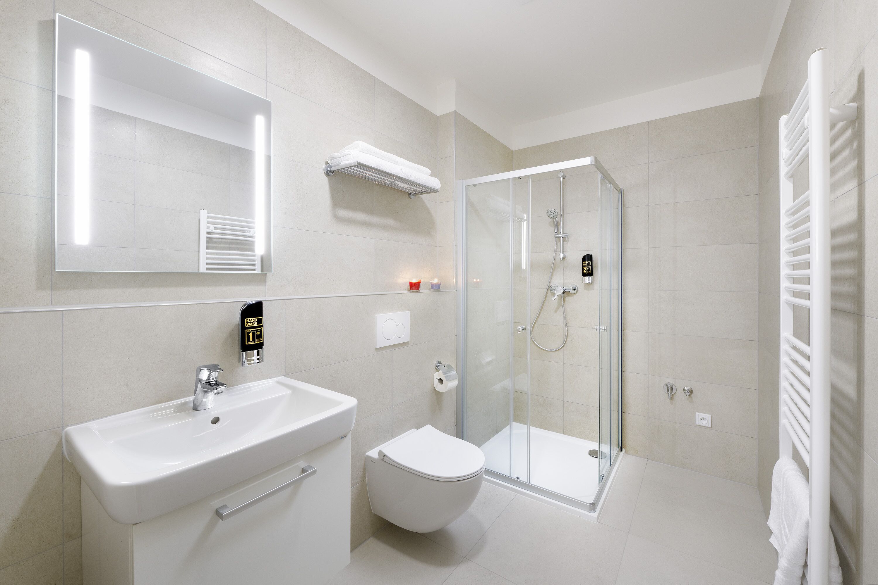 A modern bathroom with a sink, toilet, and glass shower enclosure.