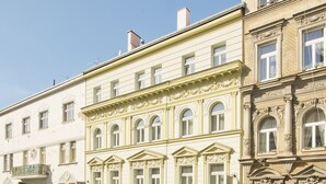 A multi-story building with classic architectural details, including ornate window frames and decorative moldings. - DownTown Suites Kodanská (Prague)