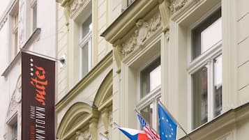 Ein Gebäude mit aufwendiger Architektur, einem Schild mit der Aufschrift 'Euro Downtown Suites' und mehreren Flaggen, darunter die amerikanische und die Flagge der Europäischen Union.