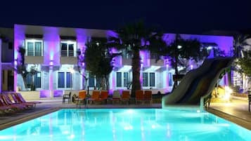 Una piscina al aire libre, sombrillas, sillones reclinables de piscina