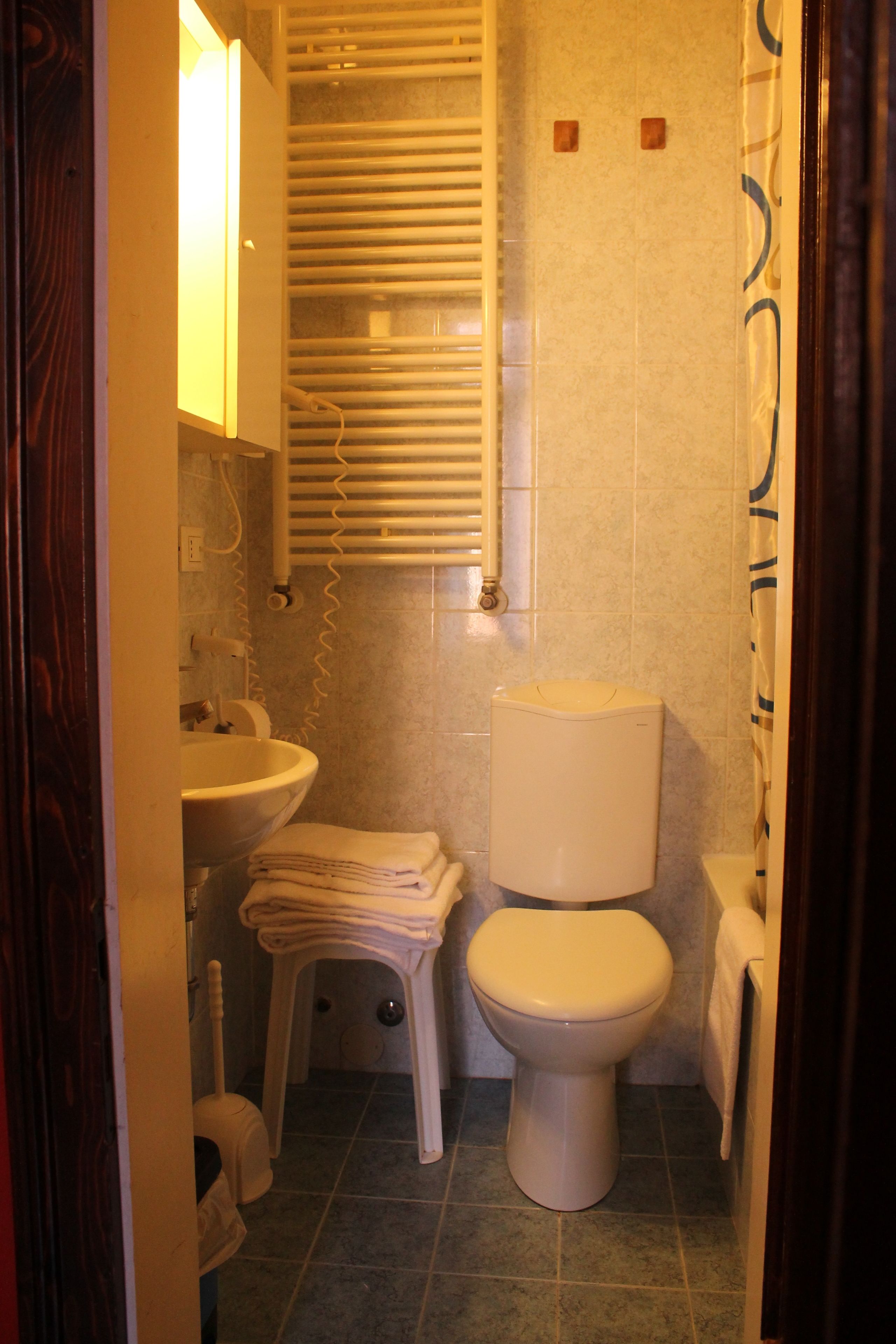 A bathroom with a toilet, sink, and shower.