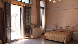 Une chambre à coucher comprenant un lit, une commode, une table de chevet et une fenêtre avec des rideaux.