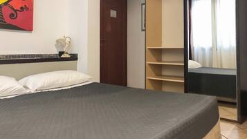 Een slaapkamer met een bed, een kast en een schilderij aan de muur.