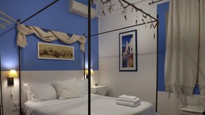 A bedroom with a four-poster bed, a nightstand, a lamp, and a chair. - Possidonea 28 Bed & Breakfast (Reggio Calabria)