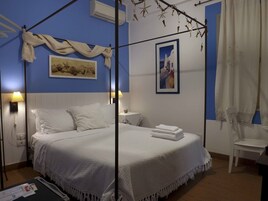 Un dormitorio con cama con dosel, mesita de noche, lámpara y una silla.