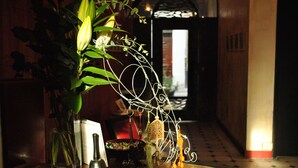 A table with a vase of flowers, a decorative metal piece, and a book. - Le Ryad Boutique Hôtel (Marseille)